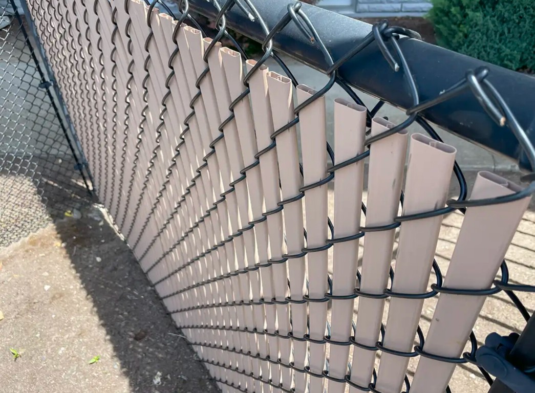 Durable chain-link fence with privacy slats for commercial properties